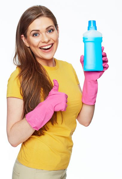 زن خندان که بطری شیمی را برای تمیز کردن خانه شو در دست دارد