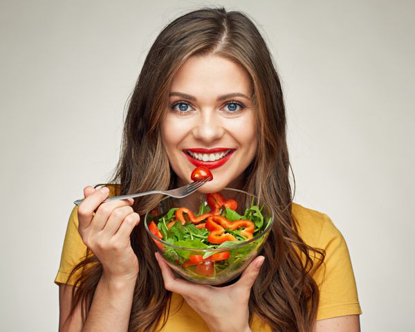 زن جوان در حال خوردن غذای سالم