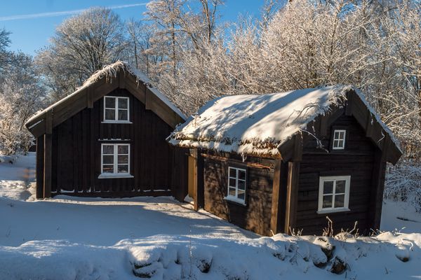 کلبه های چوبی قدیمی در چشم انداز زمستانی