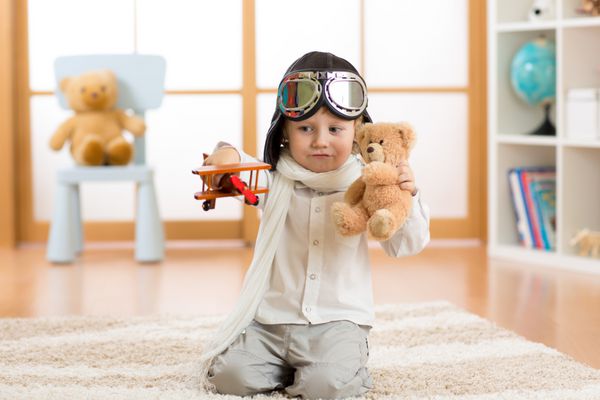 کودک نوپا شادی که با هواپیمای اسباب بازی بازی می کند و رویای خلبان شدن را دارد