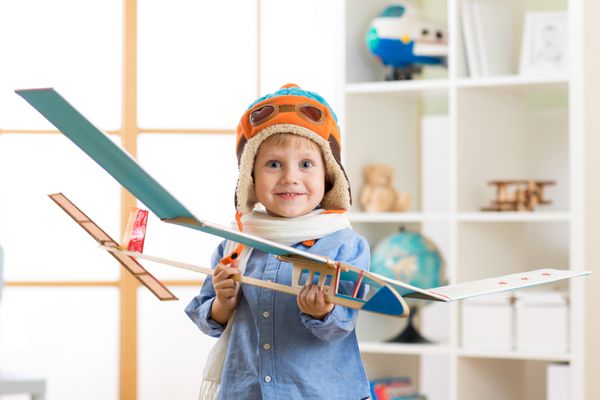 پسر بچه شاد با مدل هواپیما رویای خلبان شدن را دارد