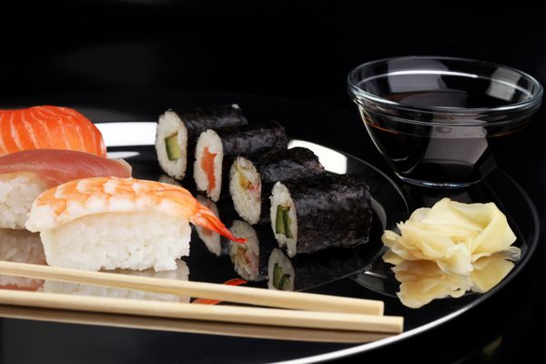کلوزآپ ست سوشی ساشیمی با چاپستیک و سویا - رول سوشی با ماهی قزل آلا و رول سوشی با مارماهی دودی فوکوس انتخابی - ماکی و نیگیری خوشمزه
