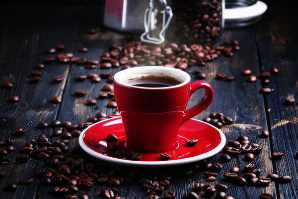 قهوه سیاه در فنجان قرمز پس زمینه سیاه فوکوس انتخابی