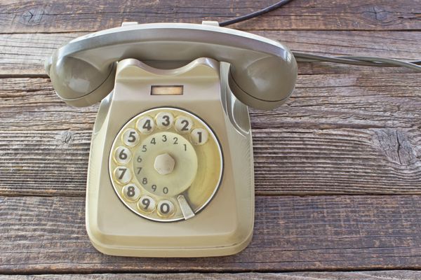 تلفن قدیمی در پس زمینه چوبی