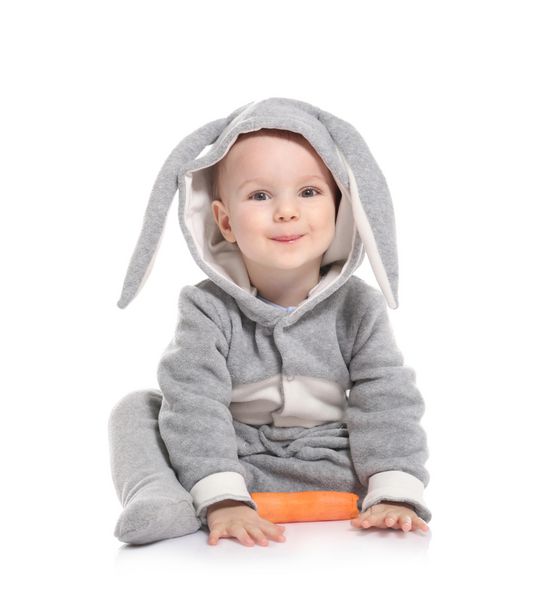 کودک کوچولوی ناز در لباس اسم حیوان دست اموز با هویج در پس زمینه سفید