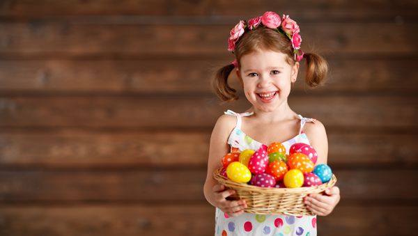 دختر بچه شاد با سبد تخم مرغ عید پاک