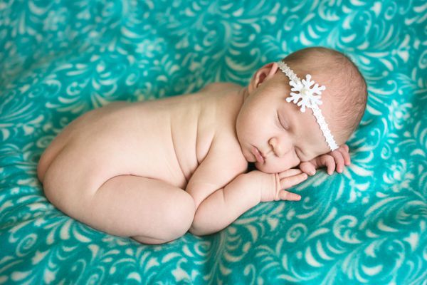 خواب نوزاد جذاب روی پس زمینه آبی سبز