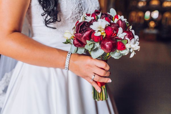 دسته گل زیبای صورتی قرمز و مارسالا از گل های مختلف در دستان عروس با لباس عروس سفید عروس با دسته گل عروسی با گل صد تومانی کالا گل رز