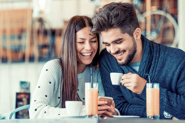 زوج جوان شاد در حال تفریح در کافه