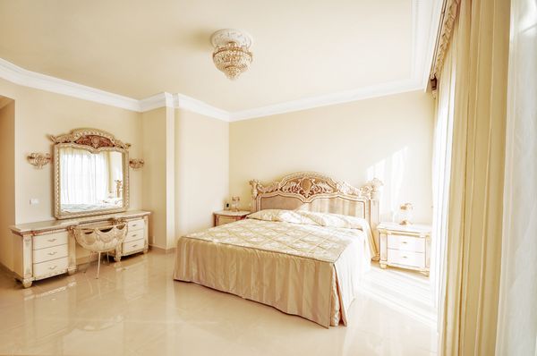 اتاق خواب مجلل در رنگ های پاستلی به سبک نئوکلاسیک با تخت بزرگ و میز آرایش با کف مرمر