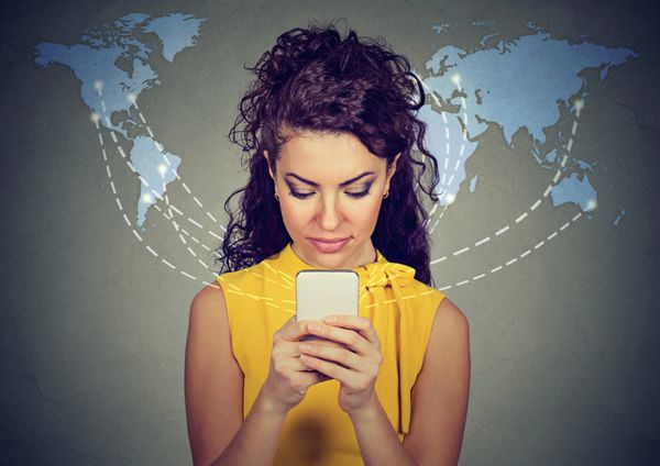 زن با استفاده از تلفن هوشمند در حال مرور اینترنت در سراسر جهان متصل است