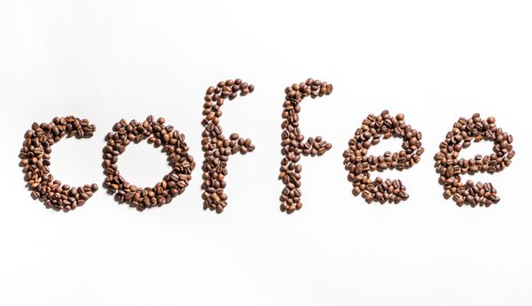 نمای بالای قهوه کلمه ساخته شده از دانه های قهوه برشته شده روی سفید