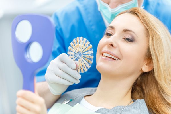 دندانپزشک مطابق رنگ دندان با پالت در کلینیک دندانپزشکی