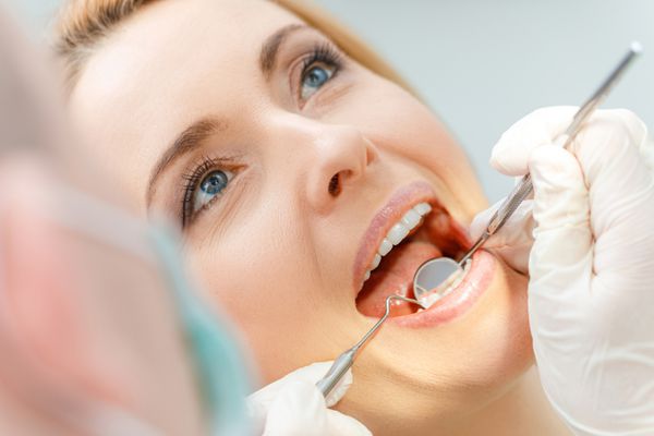 نمای نزدیک از زن میانسال زیبا در معاینه دندانپزشکی