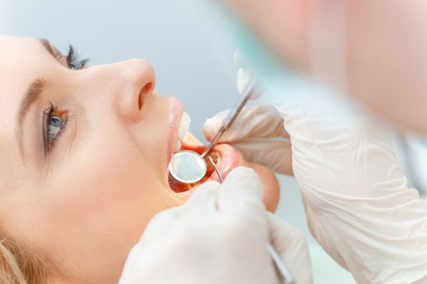 نمای نزدیک از زن میانسال زیبا در معاینه دندانپزشکی
