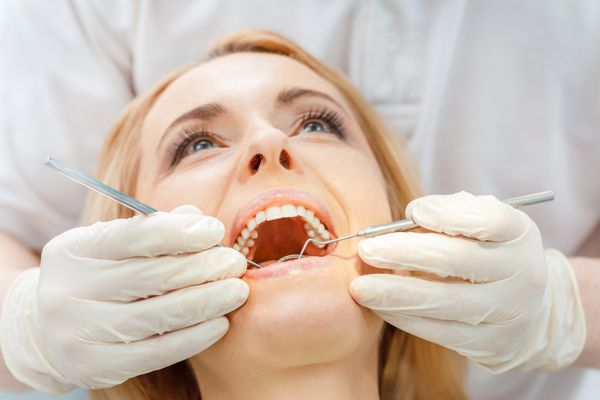 نمای نزدیک از زن بلوند در معاینه دندانپزشکی