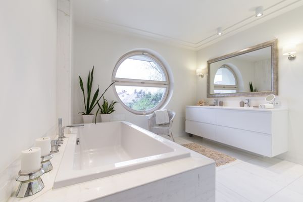 حمام سفید مینیمالیستی با پنجره مدور