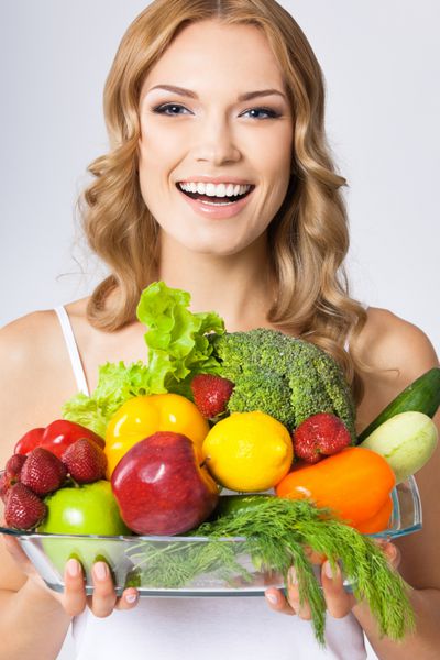 زن جوان با غذای گیاهی روی خاکستری