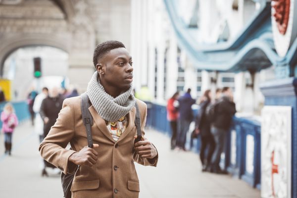 مرد جوان سیاه پوست در لندن در حال راه رفتن روی پل برج