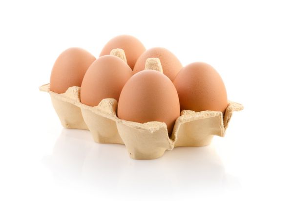 شش تخم مرغ قهوه ای در کارتن روی سفید با مسیر برش