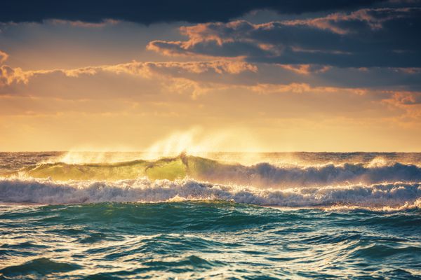 طلوع خورشید و امواج درخشان در اقیانوس