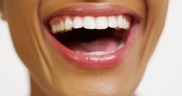 نمای نزدیک از زن آفریقایی با دندان های سفید در حال خندان
