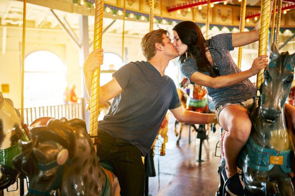 زوج عاشقانه سوار چرخ و فلک و بوسیدن
