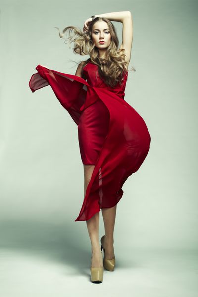 عکس مد زن جوان باشکوه با لباس قرمز عکس استودیویی