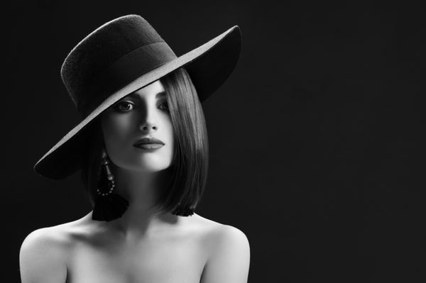 پرتره سیاه و سفید یک زن جوان زیبا با کلاه