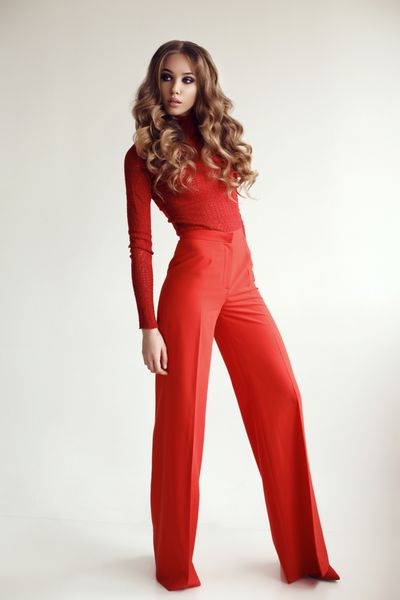 عکس آتلیه مد دختر زیبا با موهای مجعد بلند و آرایش شب در کت و شلوار قرمز