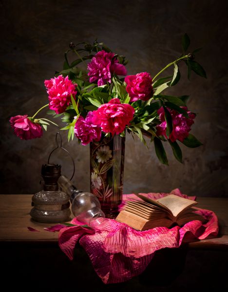 طبیعت بی جان هنری با گل صد تومانی در گلدان کتاب و لامپ