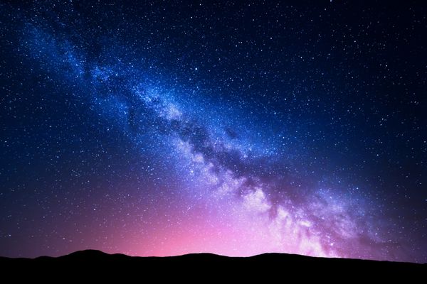 کهکشان راه شیری و نور صورتی در کوه ها منظره رنگارنگ شب آسمان پرستاره با تپه در تابستان کیهان زیبا پس زمینه فضایی با کهکشان پس زمینه سفر