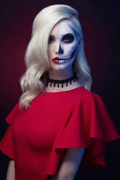 آرایش هالووین جمجمه زن زیبا با مدل مو دختر مدل Santa Muerte با لباس قرمز