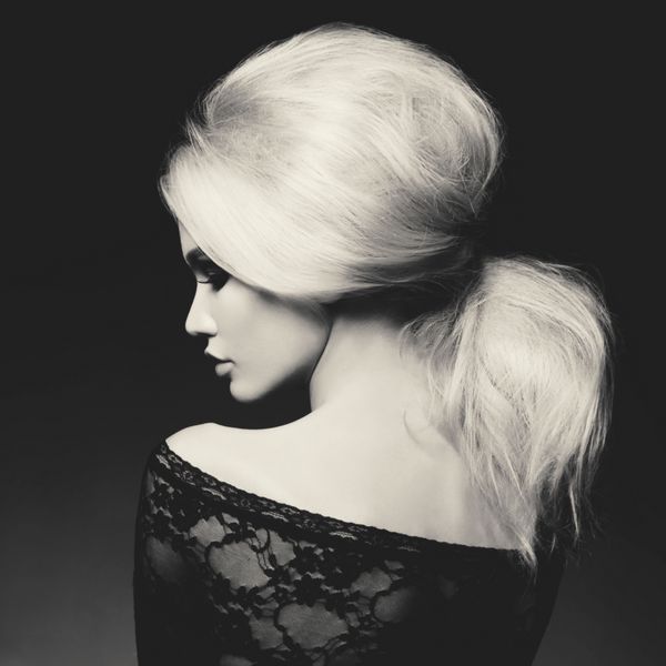 پرتره استودیو مد سیاه و سفید از زن زیبا با مدل موی زیبا در زمینه سیاه مدل موی حجم دهنده دم مو آرایشگاه