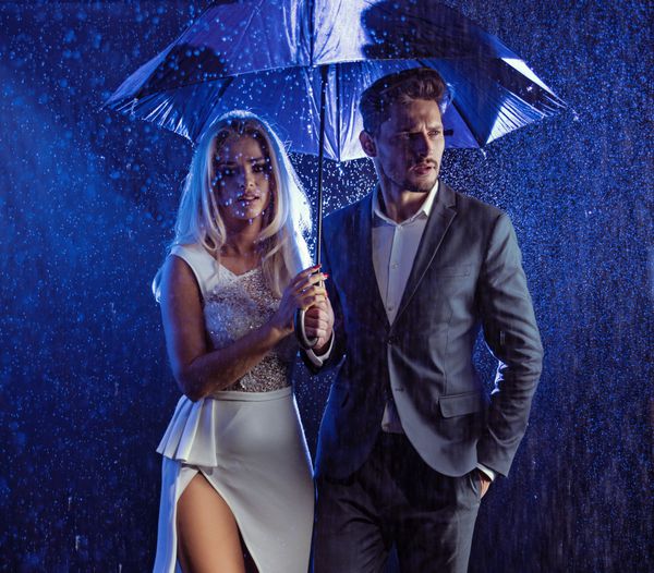 زوج جذاب زیر چتر راه رفتن در شب
