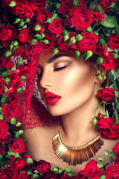 دختر مدل زیبایی با تاج گل رز قرمز و آرایش مد مدل موی گل بانوی زیبا با گلهای شکوفه بر سر مدل موی طبیعت آرایش مد تعطیلات با رژ لب قرمز