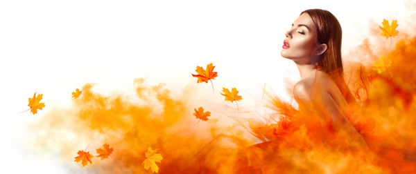 زن زیبای مد بالا با لباس زرد پاییزی با برگ های در حال سقوط در استودیو ژست گرفته است دختر مدل شیک با آرایش زیبا پوشیدن لباس شب خیره کننده با لباس مجلسی بلند از پارچه توری
