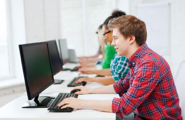 مفهوم آموزش - دانش آموز با کامپیوتر در حال تحصیل در مدرسه