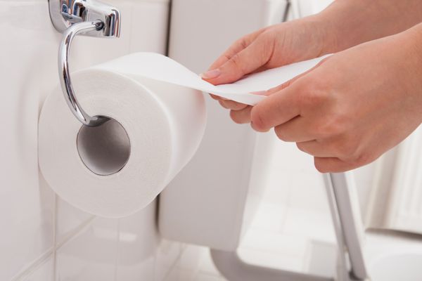 نمای نزدیک از دست یک شخص با استفاده از دستمال توالت