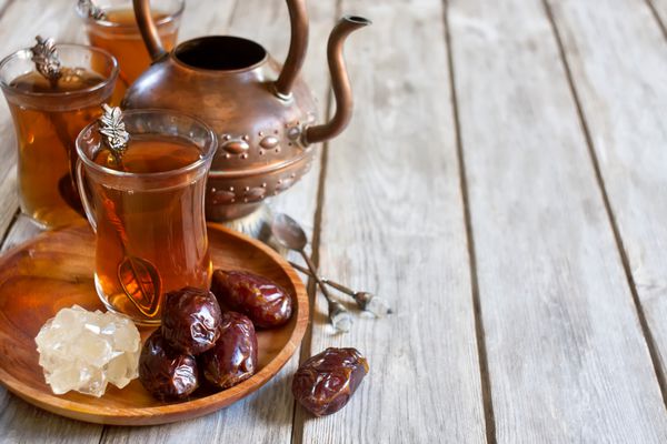 چای سنتی عربی با خرما خشک و شکر نبات تمرکز انتخابی پس زمینه فضا را کپی کنید