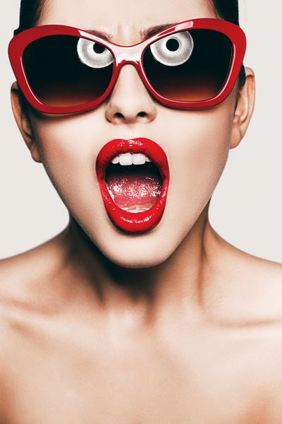 زن با عینک آفتابی قرمز با دهان باز