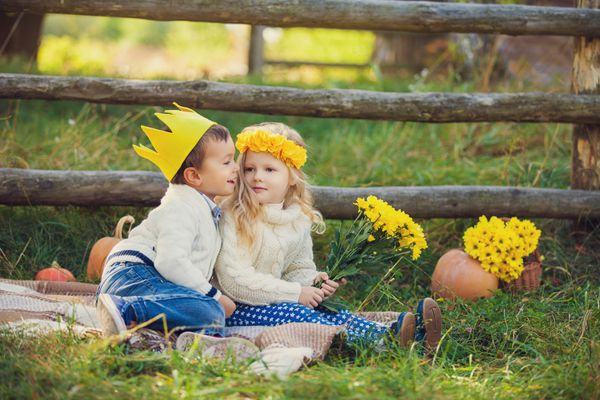 بچه های شاد شایان ستایش در فضای باز در روز آفتابی در باغ پاییزی زرد زیبا