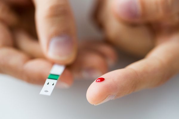 دارو دیابت قند خون مراقبت های بهداشتی و مفهوم مردم - نمای نزدیک انگشت مرد با قطره خون و نوار تست