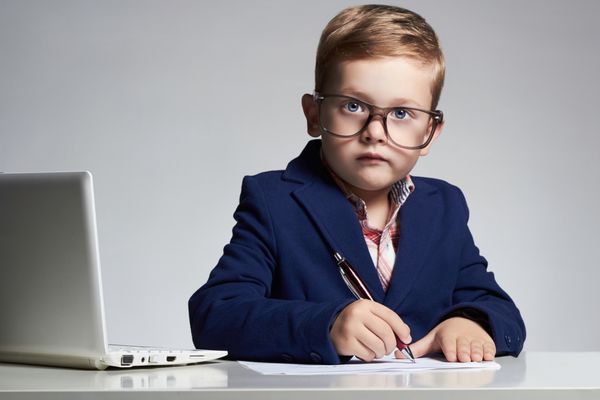 پسر جوان تاجر کودک بامزه با عینک خودکار نوشتن رئیس کوچک در دفتر