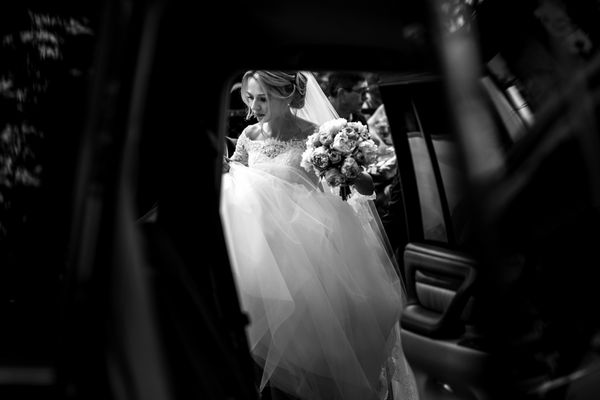 سیاه و سفید عروس عروسی زیبا با لباس سفید سوار ماشین شیک