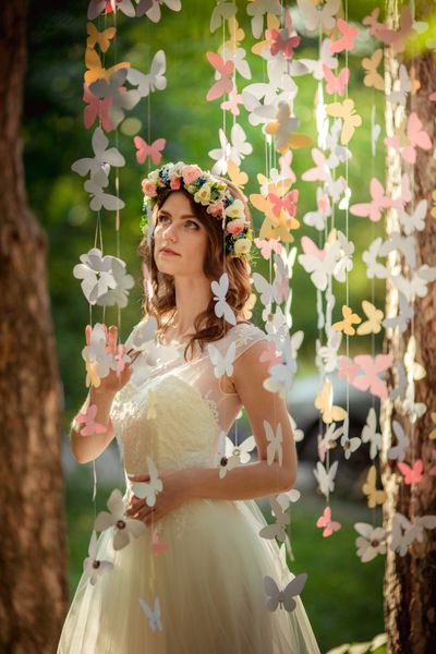 عروس زیبا با لباس سفید در باغ