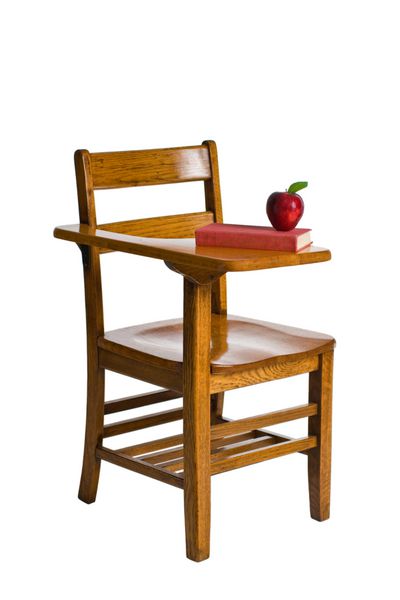 یک میز مدرسه چوبی با یک کتاب قرمز و یک سیب جدا شده روی سفید
