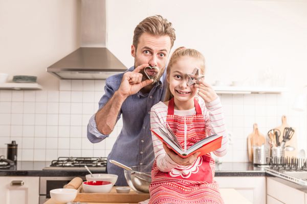 سرگرمی پدر و دختر قفقازی در حالی که آماده پختن کلوچه در آشپزخانه می شوند - اوقات خوشی برای خانواده
