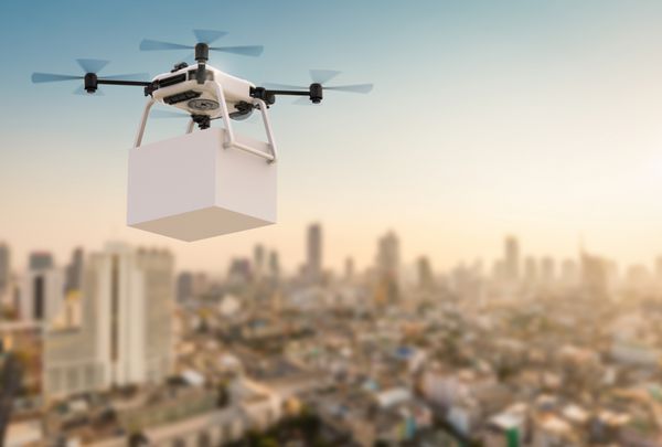 هواپیمای بدون سرنشین تحویل رندر سه بعدی در حال پرواز با پس زمینه شهر