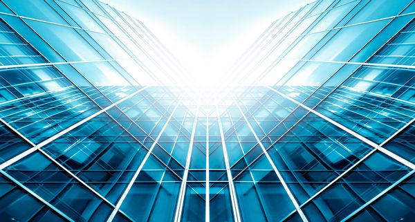 نمای پانوراما و پرسپکتیو زاویه باز به پس زمینه آبی روشن فولادی ساختمان بلند شیشه ای آسمان خراش تجاری مدرن شهر آینده مفهوم تجاری معماری فناوری صنعت موفقیت